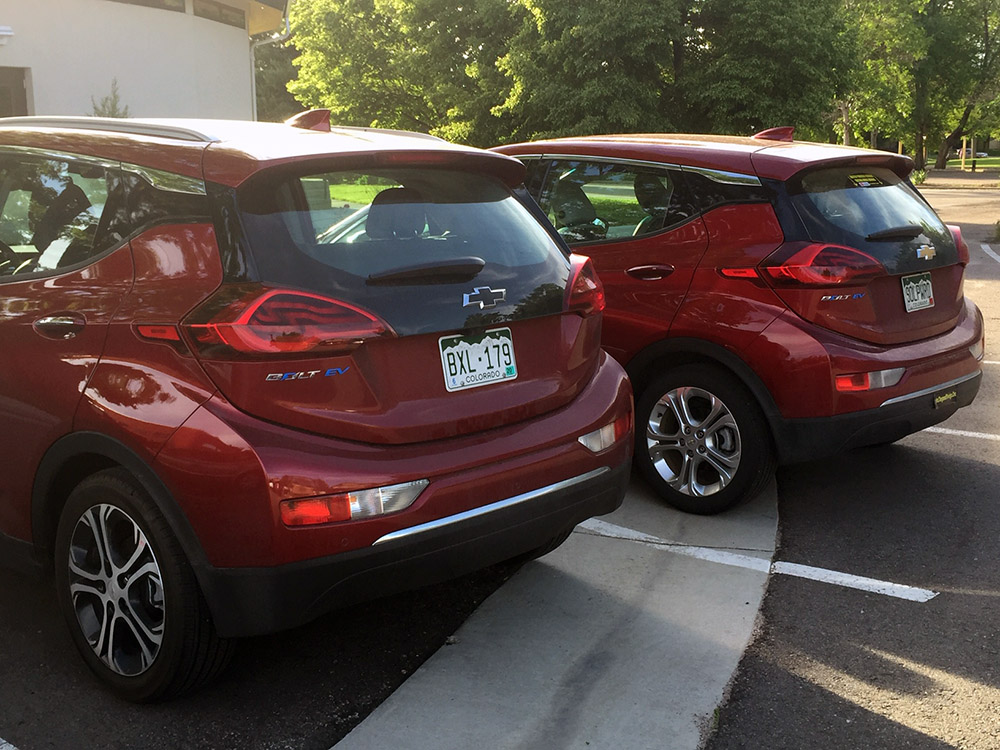 Two red Chevy Bolts parked next to each other.