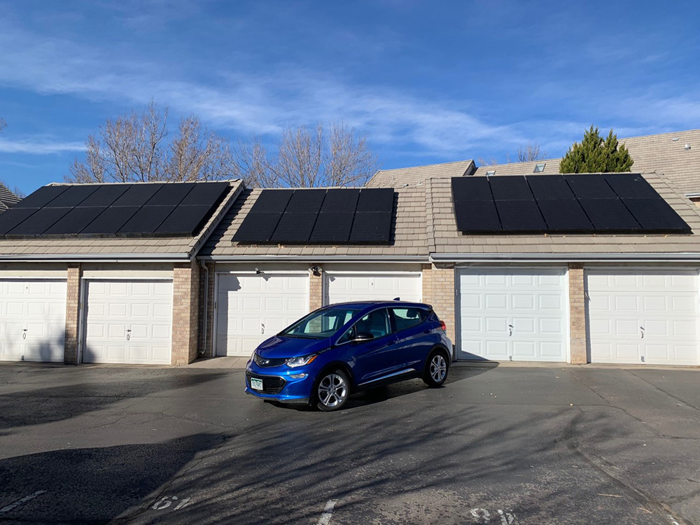 a solar EV in front of a garage with solar panels